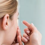 Woman putting on contact lenses